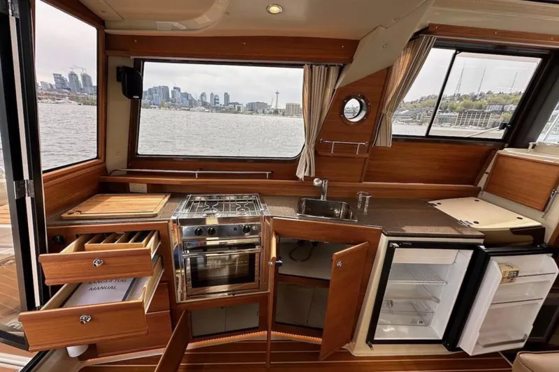 Flips Ahoy Yacht Photos Pics Interior of 2021 Ranger Tugs R-29 S boat with kitchen and city view.