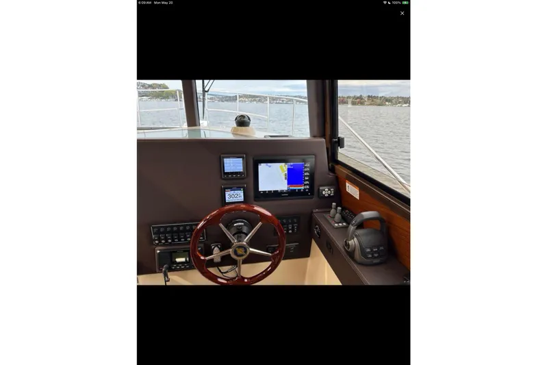 Flips Ahoy Yacht Photos Pics 2021 Ranger Tugs R-29 S helm with navigation screens and steering wheel on a calm waterway.