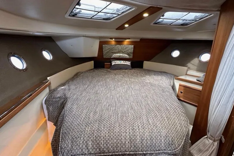 Flips Ahoy Yacht Photos Pics 2021 Ranger Tugs R-29 S cabin interior with cozy bed and porthole windows.