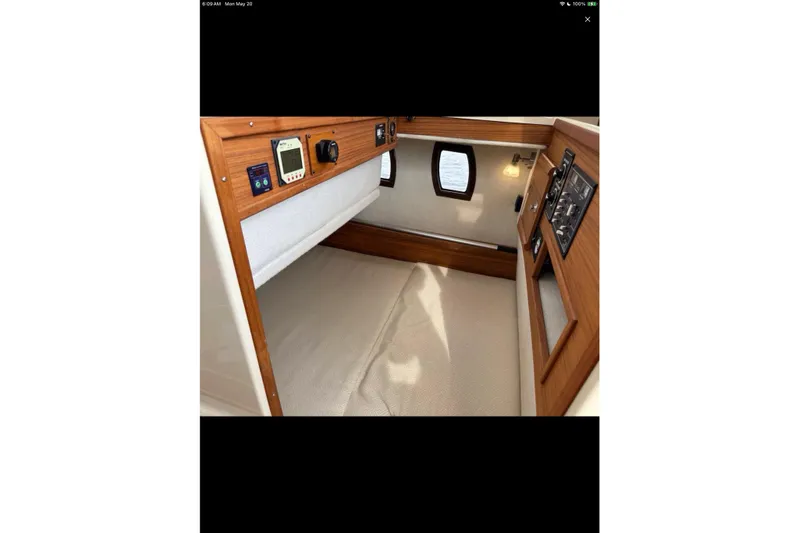 Flips Ahoy Yacht Photos Pics 2021 Ranger Tugs R-29 S cabin interior with control panels and cozy sleeping area.