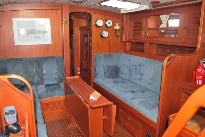  Yacht Photos Pics Interior of 1988 Hallberg-Rassy 42 yacht with wooden furnishings and blue upholstery.