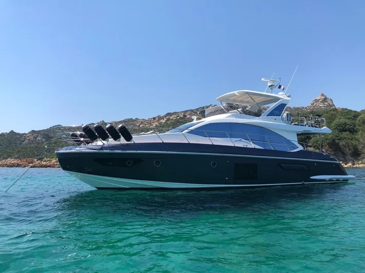  Yacht Photos Pics 2018 Azimut 55 yacht on clear turquoise water near rocky coastline.
