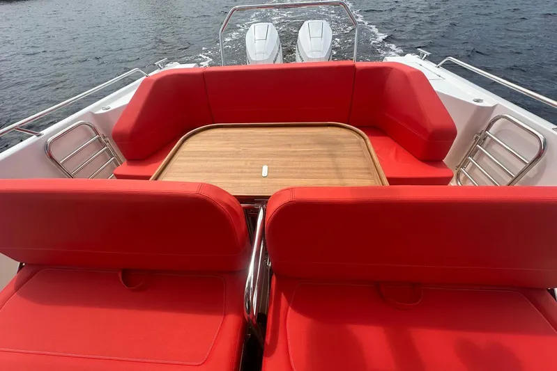  Yacht Photos Pics 2025 Nimbus Tender 11 boat with red seating and wooden table on open water.