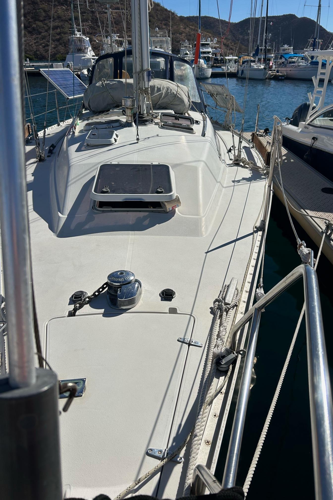 1988 CS 36 Merlin sailboat docked in a marina, featuring a clean deck and scenic background.