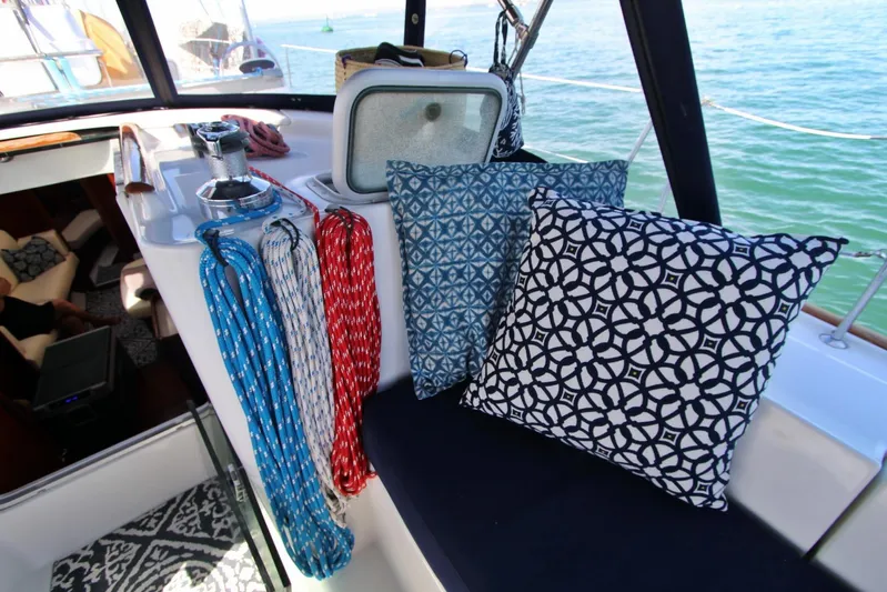  Yacht Photos Pics Cozy cockpit of 2003 Beneteau 473 sailboat with patterned cushions and colorful ropes.