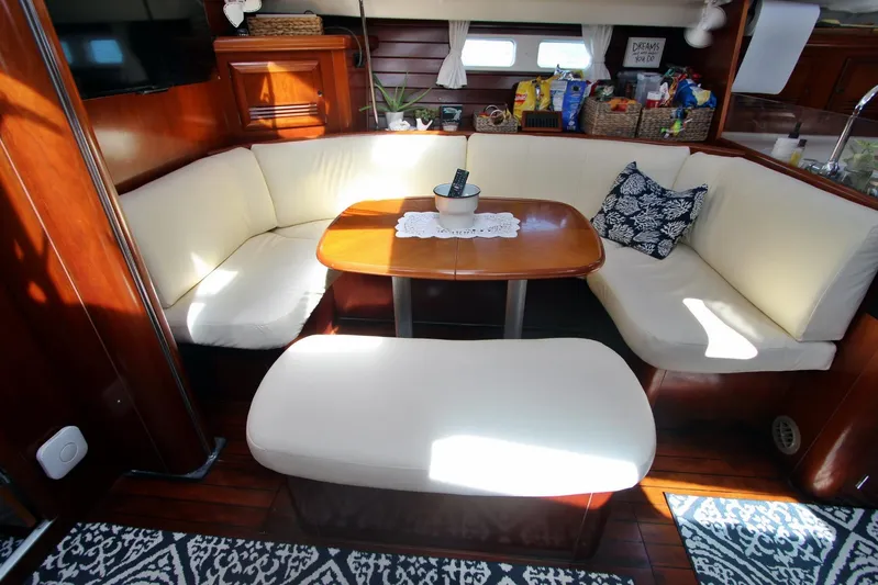  Yacht Photos Pics Interior of 2003 Beneteau 473 yacht with cozy seating and wooden table.