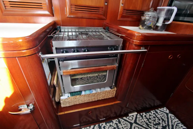  Yacht Photos Pics Galley kitchen in 2003 Beneteau 473 yacht with stove and wooden cabinetry.