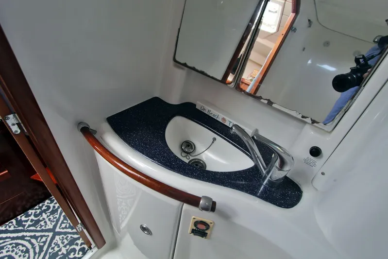  Yacht Photos Pics Bathroom sink area in a 2003 Beneteau 473 yacht, featuring a sleek countertop and mirror.
