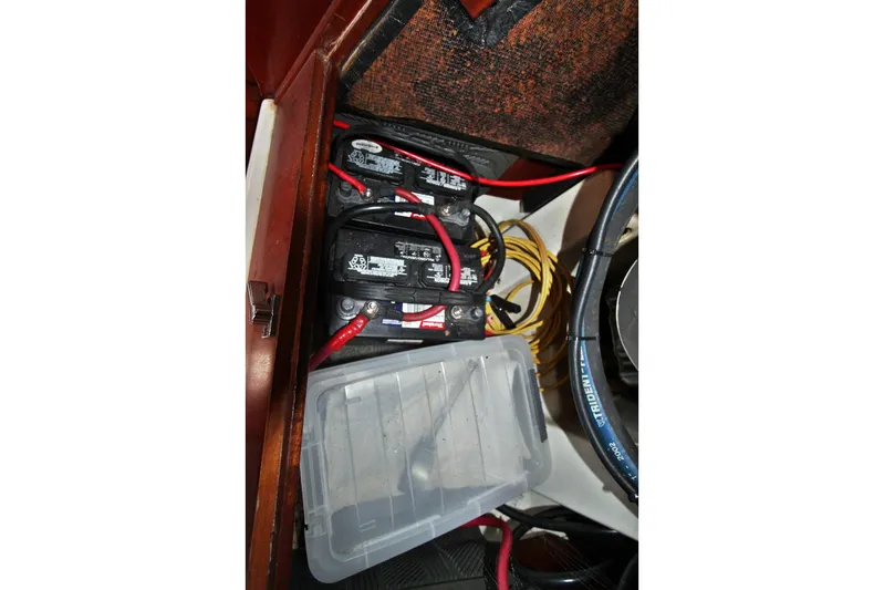  Yacht Photos Pics Battery compartment of a 2003 Beneteau 473 sailboat with wiring and storage box.
