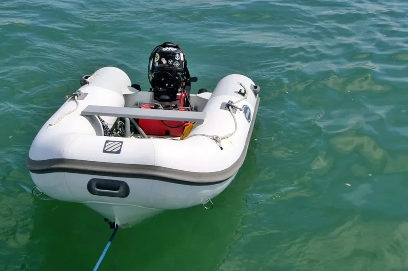 Yacht Photos Pics Inflatable dinghy with outboard motor on water, associated with 2003 Beneteau 473 yacht.