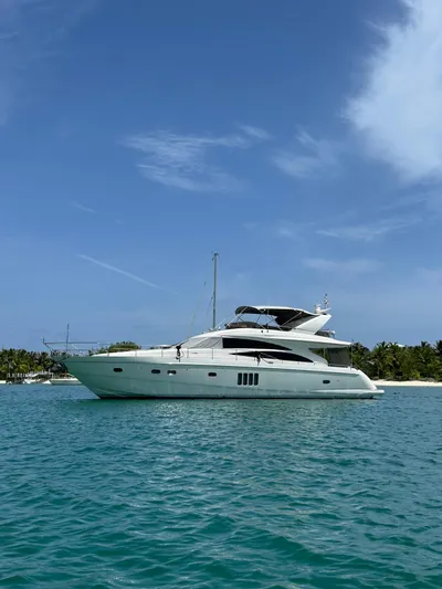 Uniq III Yacht Photos Pics Luxury 2008 Princess 67 Flybridge yacht on turquoise water, clear sky background.