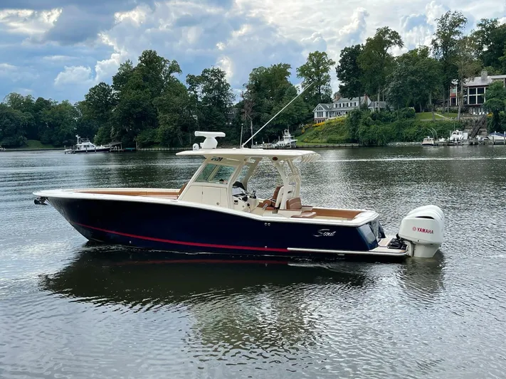  Yacht Photos Pics 2016 Scout 350 LXF boat on a calm lake with scenic background.