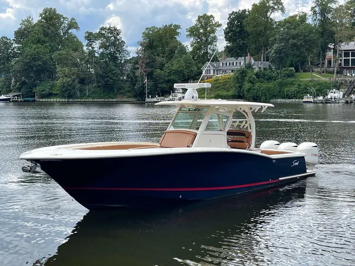  Yacht Photos Pics 2016 Scout 350 LXF boat on a serene lake with lush greenery.