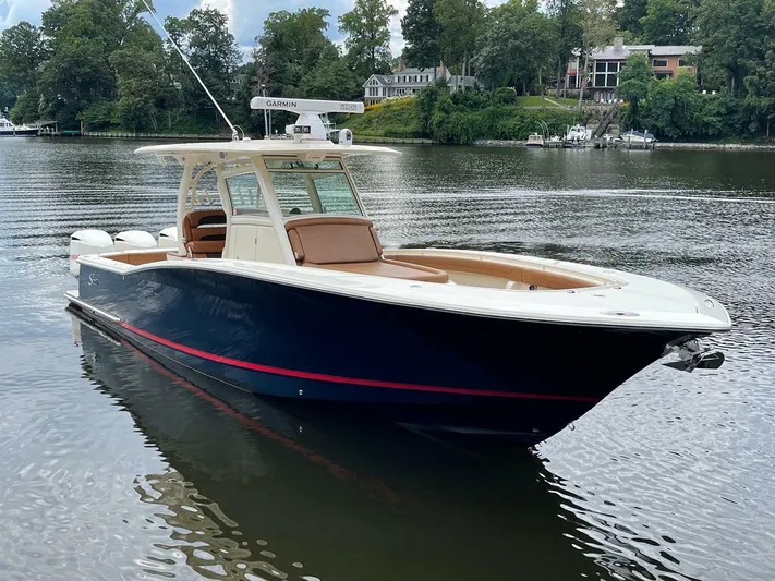  Yacht Photos Pics 2016 Scout 350 LXF boat on calm water, surrounded by lush greenery and waterfront homes.