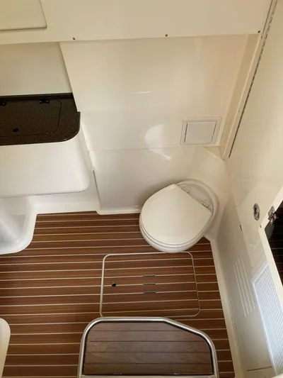  Yacht Photos Pics 2016 Scout 350 LXF boat interior with wooden flooring and compact toilet.