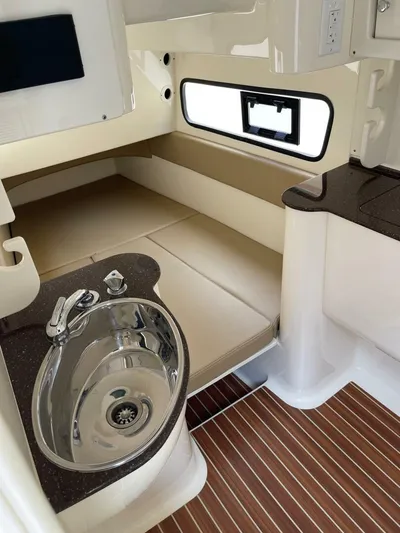  Yacht Photos Pics 2016 Scout 350 LXF cabin interior with sink, cushioned seating, and wood-patterned flooring.