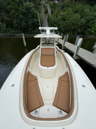  Yacht Photos Pics 2016 Scout 350 LXF boat with tan seating, docked near lush greenery.
