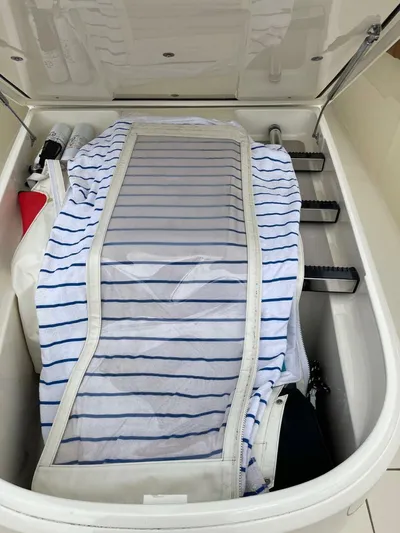  Yacht Photos Pics Storage compartment in a 2016 Scout 350 LXF boat, containing striped fabric and equipment.