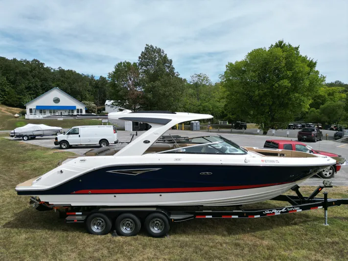  Yacht Photos Pics 2022 Sea Ray SLX 310 boat on trailer, parked outdoors near trees and vehicles.