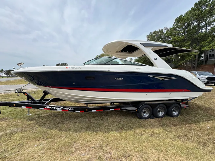  Yacht Photos Pics 2022 Sea Ray SLX 310 boat on trailer, parked on grass, side view.