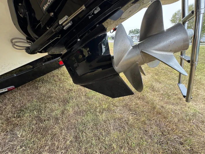  Yacht Photos Pics Propeller of 2022 Sea Ray SLX 310 boat on grassy surface.