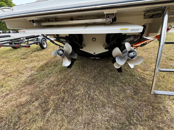  Yacht Photos Pics 2022 Sea Ray SLX 310 boat propellers and stern on grassy area.