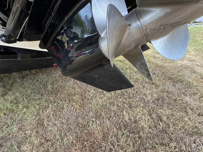  Yacht Photos Pics Close-up of a 2022 Sea Ray SLX 310 boat propeller on grass.