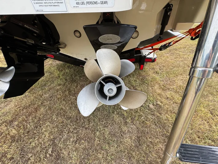  Yacht Photos Pics Propeller of 2022 Sea Ray SLX 310 boat on grass, close-up view.