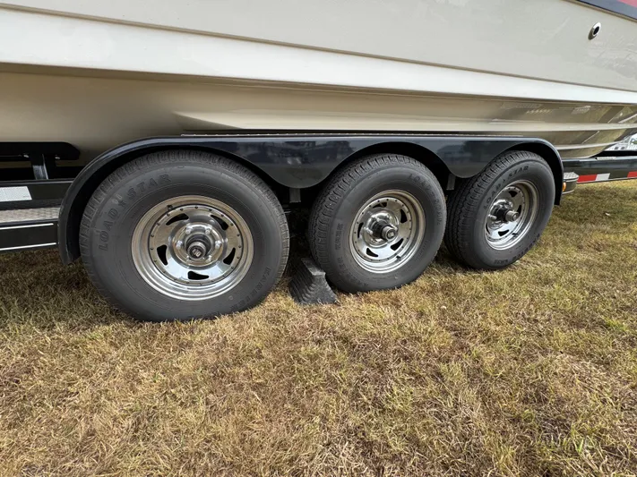  Yacht Photos Pics Trailer with triple axles for 2022 Sea Ray SLX 310 boat on grass.