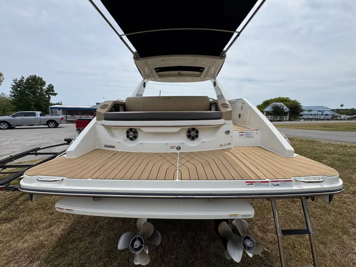  Yacht Photos Pics 2022 Sea Ray SLX 310 boat with spacious deck and seating, parked on grass.