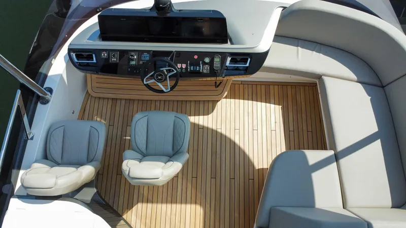 F65020 Yacht Photos Pics 2024 Princess F65 yacht cockpit with modern helm, luxurious seating, and teak flooring.