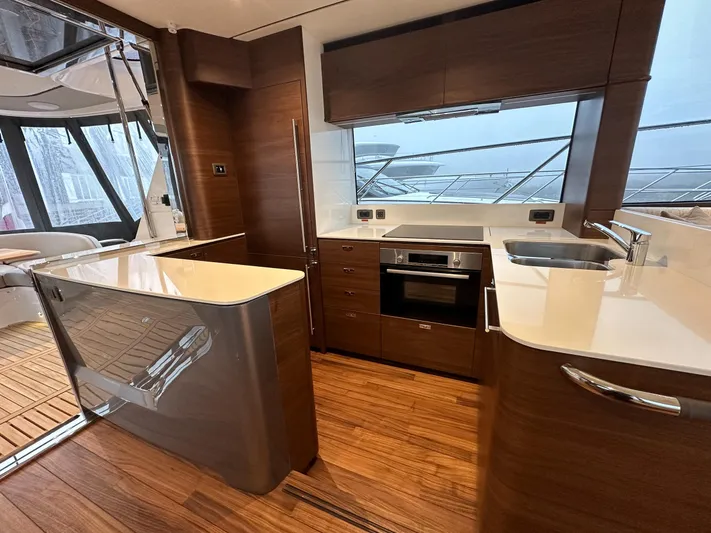 F65020 Yacht Photos Pics Luxurious 2024 Princess F65 yacht kitchen with modern wood cabinetry and sleek countertops.