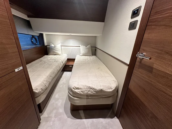 F65020 Yacht Photos Pics 2024 Princess F65 yacht cabin with twin beds and modern wood finish.