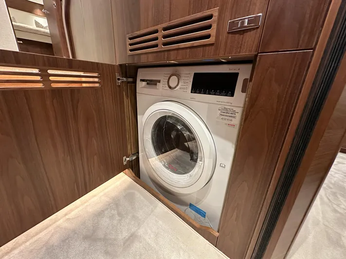 F65020 Yacht Photos Pics Built-in washing machine in a 2024 Princess F65 yacht, wooden cabinet design.