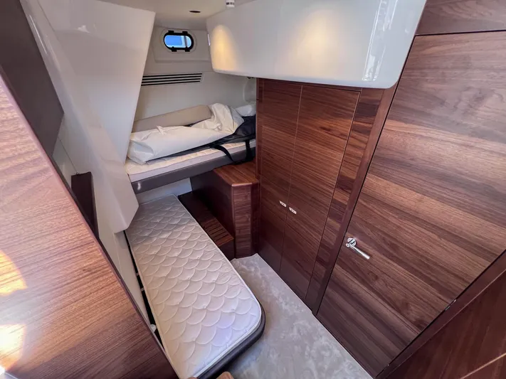 F65020 Yacht Photos Pics Luxurious cabin interior of 2024 Princess F65 yacht with wooden finishes and cozy bedding.