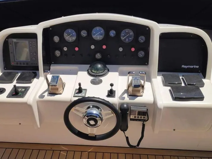 Yaiza Yacht Photos Pics Control panel of a 2000 Astondoa 82 GLX yacht with navigation instruments and steering wheel.