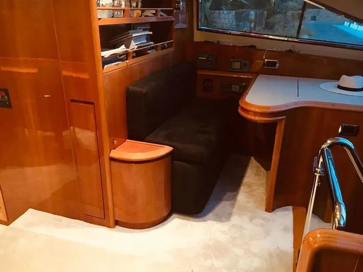 Yaiza Yacht Photos Pics Luxurious interior of 2000 Astondoa 82 GLX yacht with wooden cabinetry and seating area.
