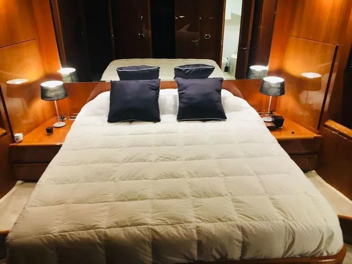 Yaiza Yacht Photos Pics Luxurious bedroom interior of 2000 Astondoa 82 GLX yacht with elegant bedding and warm lighting.