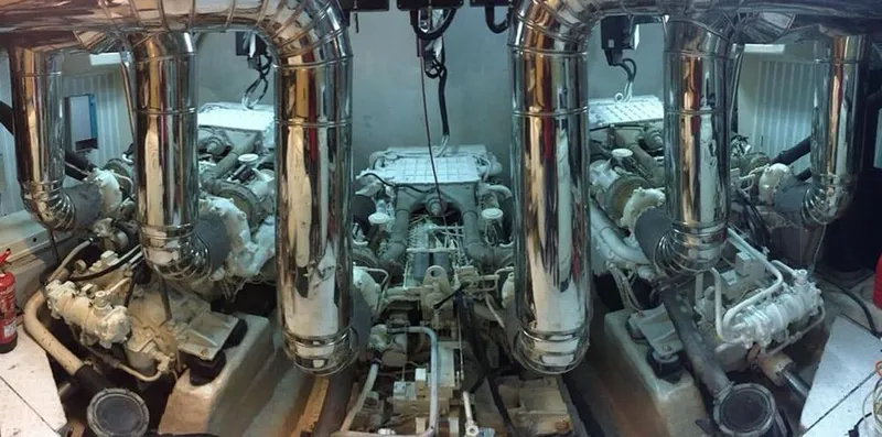Yaiza Yacht Photos Pics Engine room of 2000 Astondoa 82 GLX yacht with polished metal pipes and machinery.