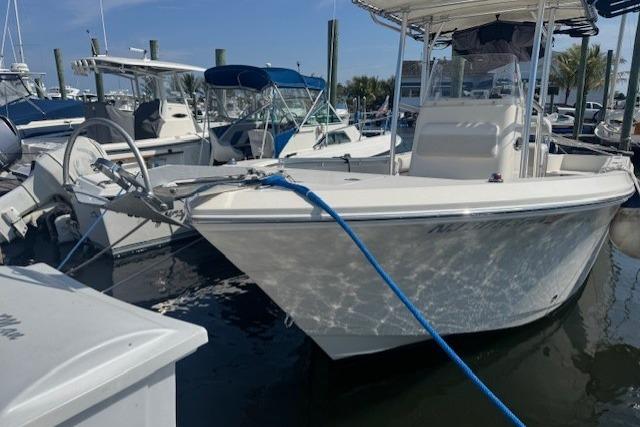 2014 Cobia 217 Center Console boat docked at a marina with blue rope.