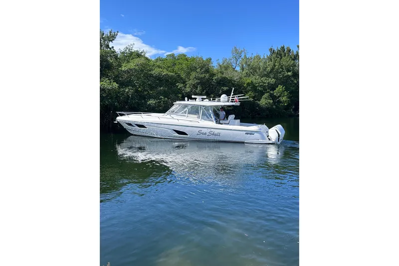 No Name Yacht Photos Pics 2020 Intrepid 409 Valor boat cruising on a calm river with lush greenery.