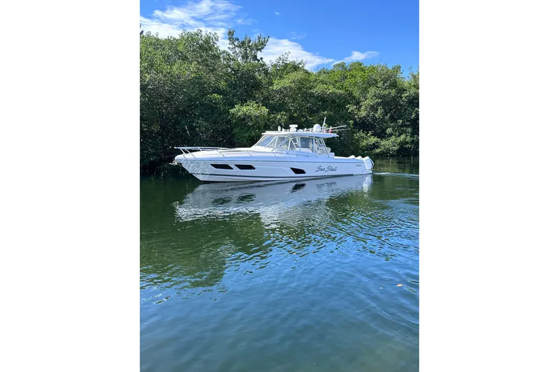 No Name Yacht Photos Pics 2020 Intrepid 409 Valor boat cruising on a calm river with lush greenery.