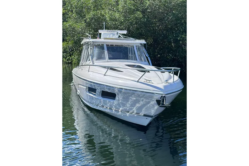 No Name Yacht Photos Pics 2020 Intrepid 409 Valor boat on calm water, surrounded by lush greenery.