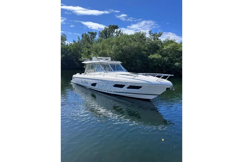 No Name Yacht Photos Pics 2020 Intrepid 409 Valor boat on calm water with lush greenery background.