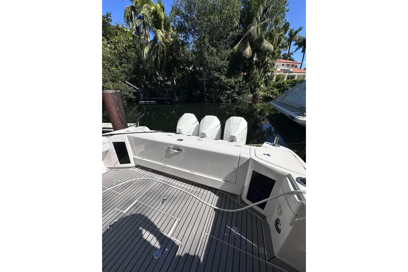 No Name Yacht Photos Pics 2020 Intrepid 409 Valor boat with triple engines docked near lush greenery.