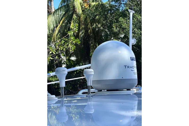 No Name Yacht Photos Pics Satellite equipment on 2020 Intrepid 409 Valor boat, surrounded by tropical foliage.
