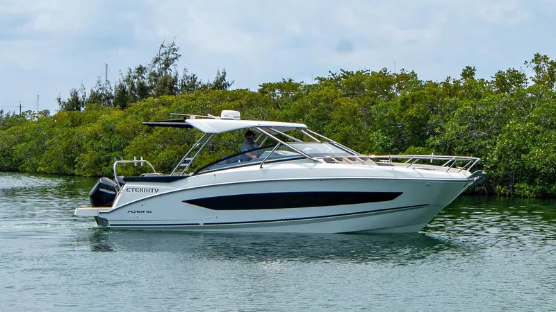 Eternity Yacht Photos Pics 2023 Beneteau Flyer 10 boat cruising on calm water near lush greenery.