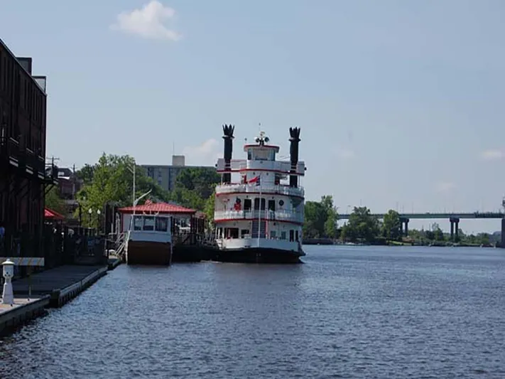 Capt. Jp III Yacht Photos Pics Custom 1985 Serodino Dinner Boat docked by riverside with bridge in background.