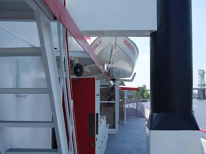 Capt. Jp III Yacht Photos Pics 1985 Custom Serodino Dinner Boat with lifeboat, docked by a river, featuring red and white accents.
