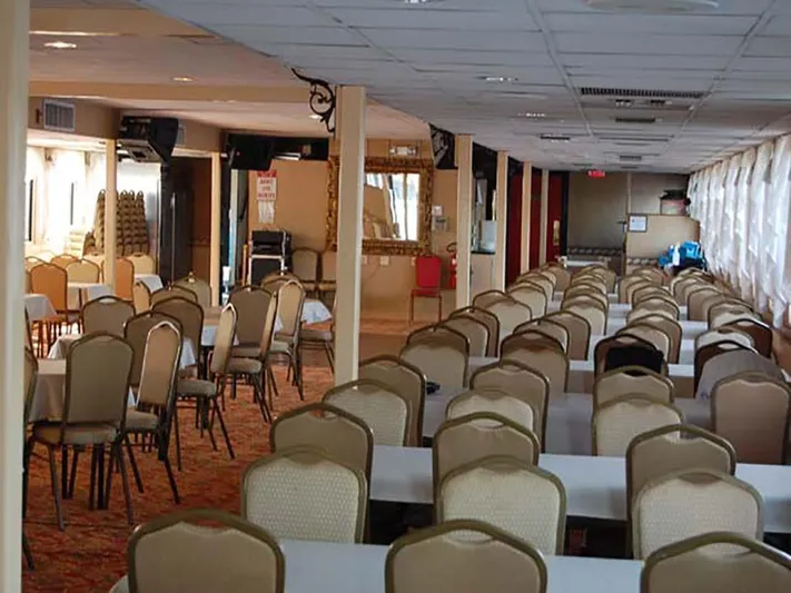 Capt. Jp III Yacht Photos Pics Interior of 1985 Custom Serodino Dinner Boat with rows of tables and chairs.